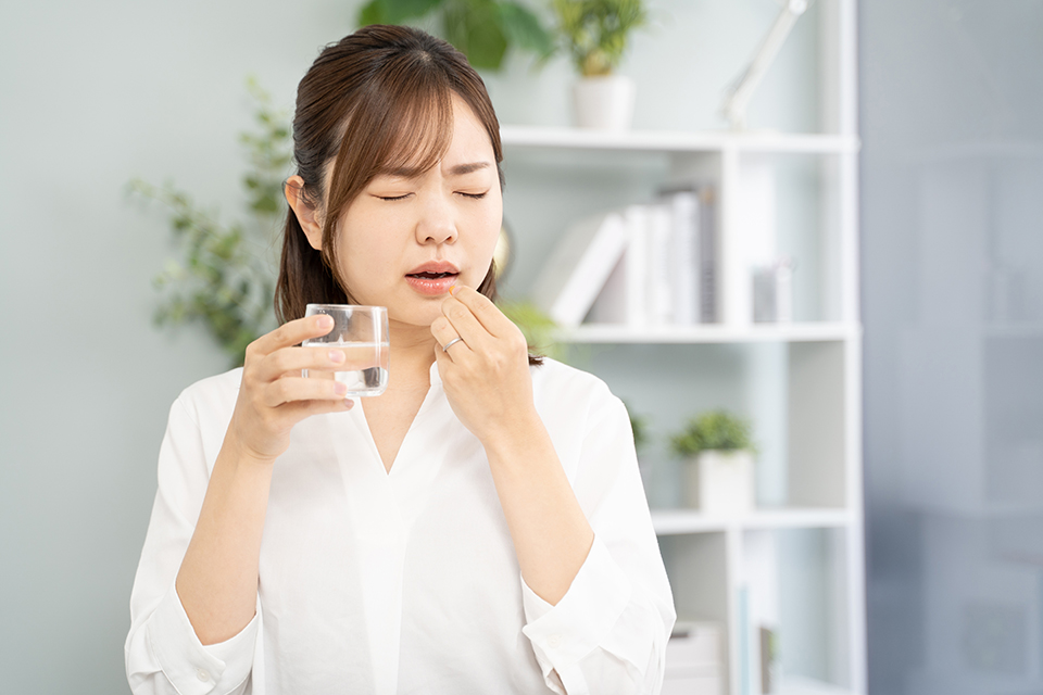 薬を飲む女性