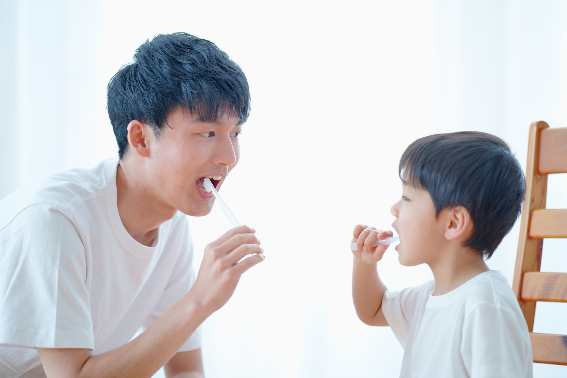 子供と歯磨きをする男性