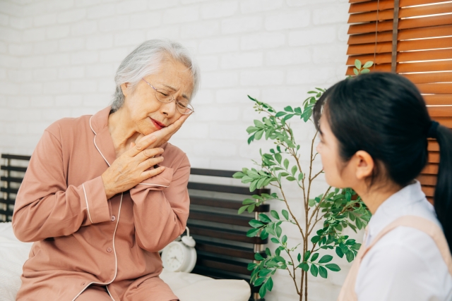 頬を抑える高齢女性