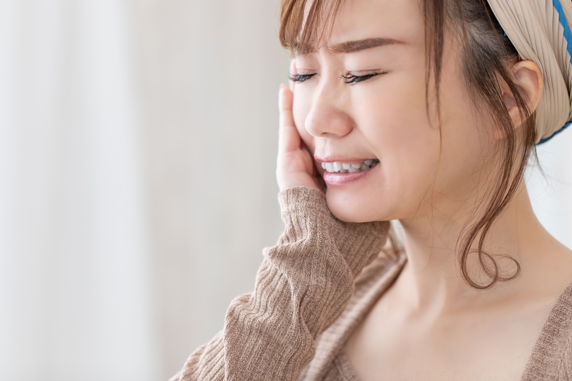 頬をおさえる女性