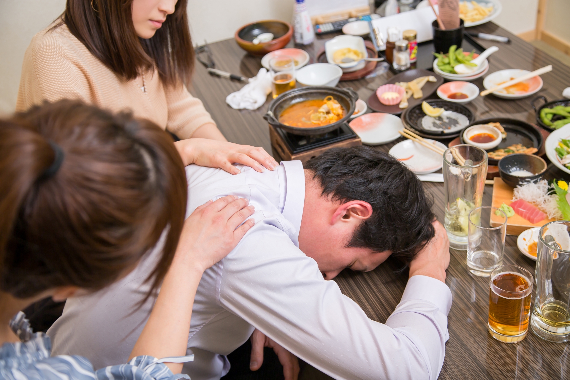 酔いつぶれる男性を介抱する