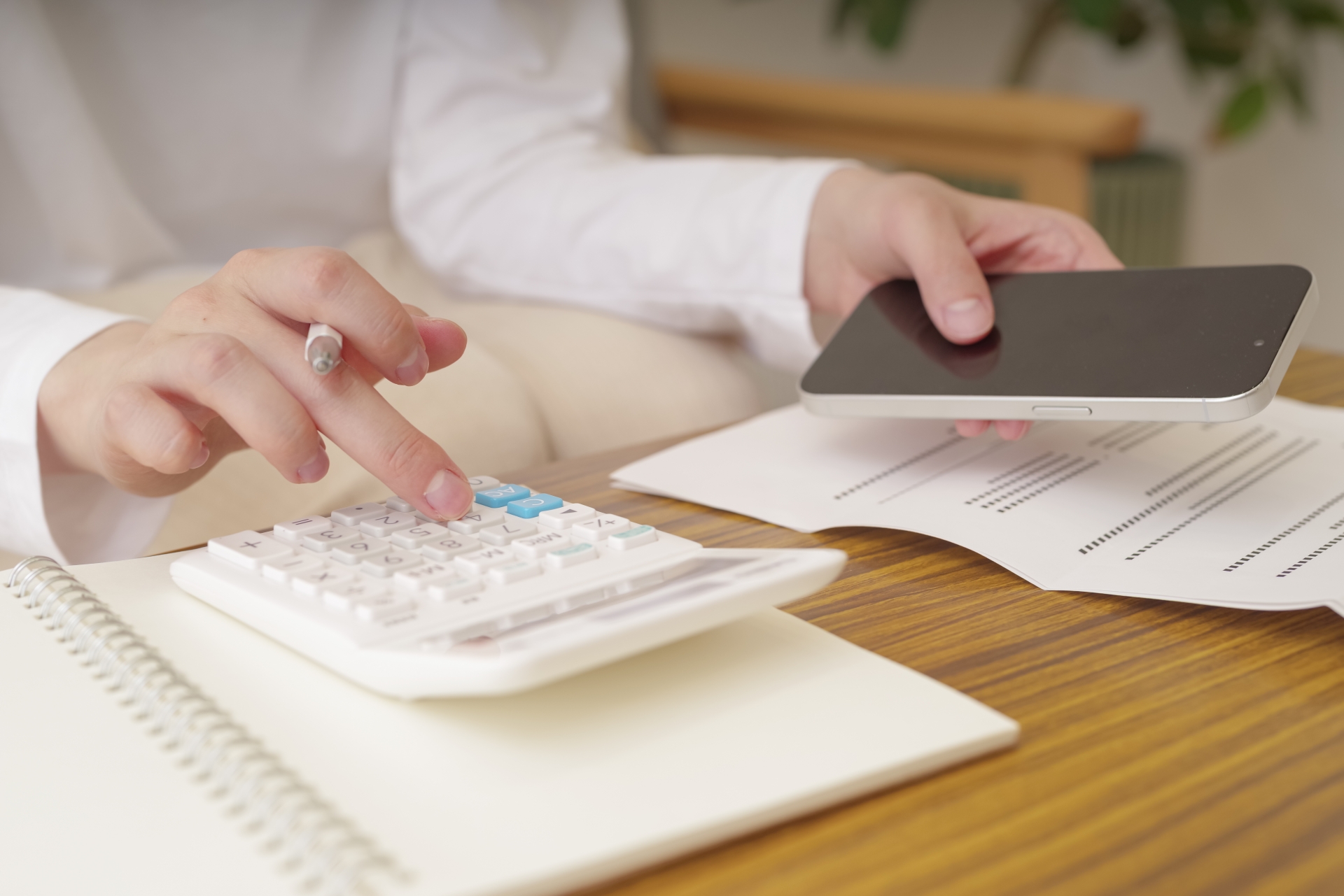 電卓でお金の計算をする女性