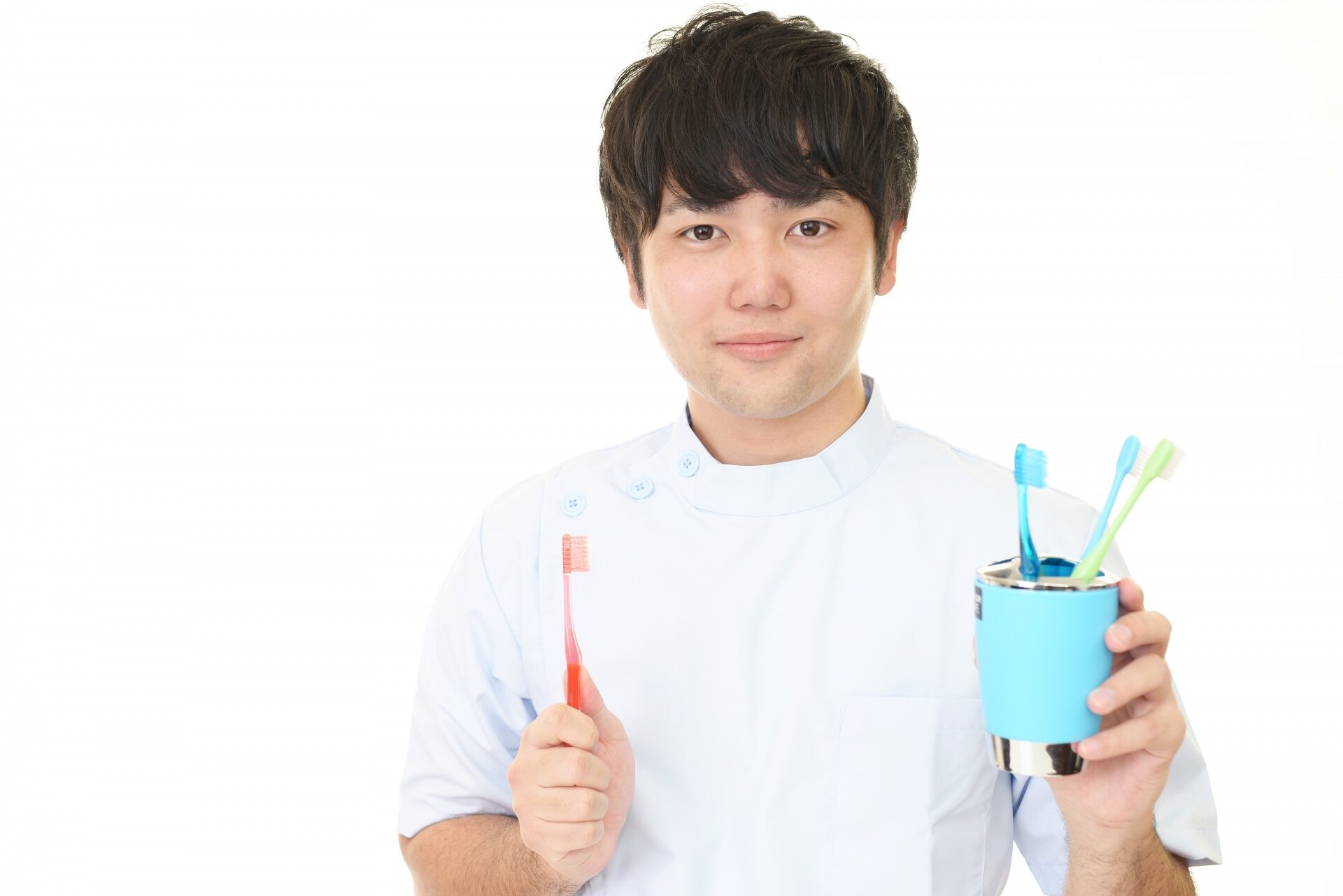 歯ブラシを持つ歯科医師