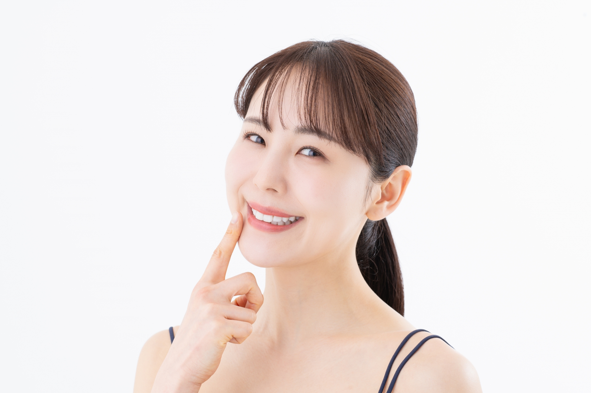 口元を指さす若い女性