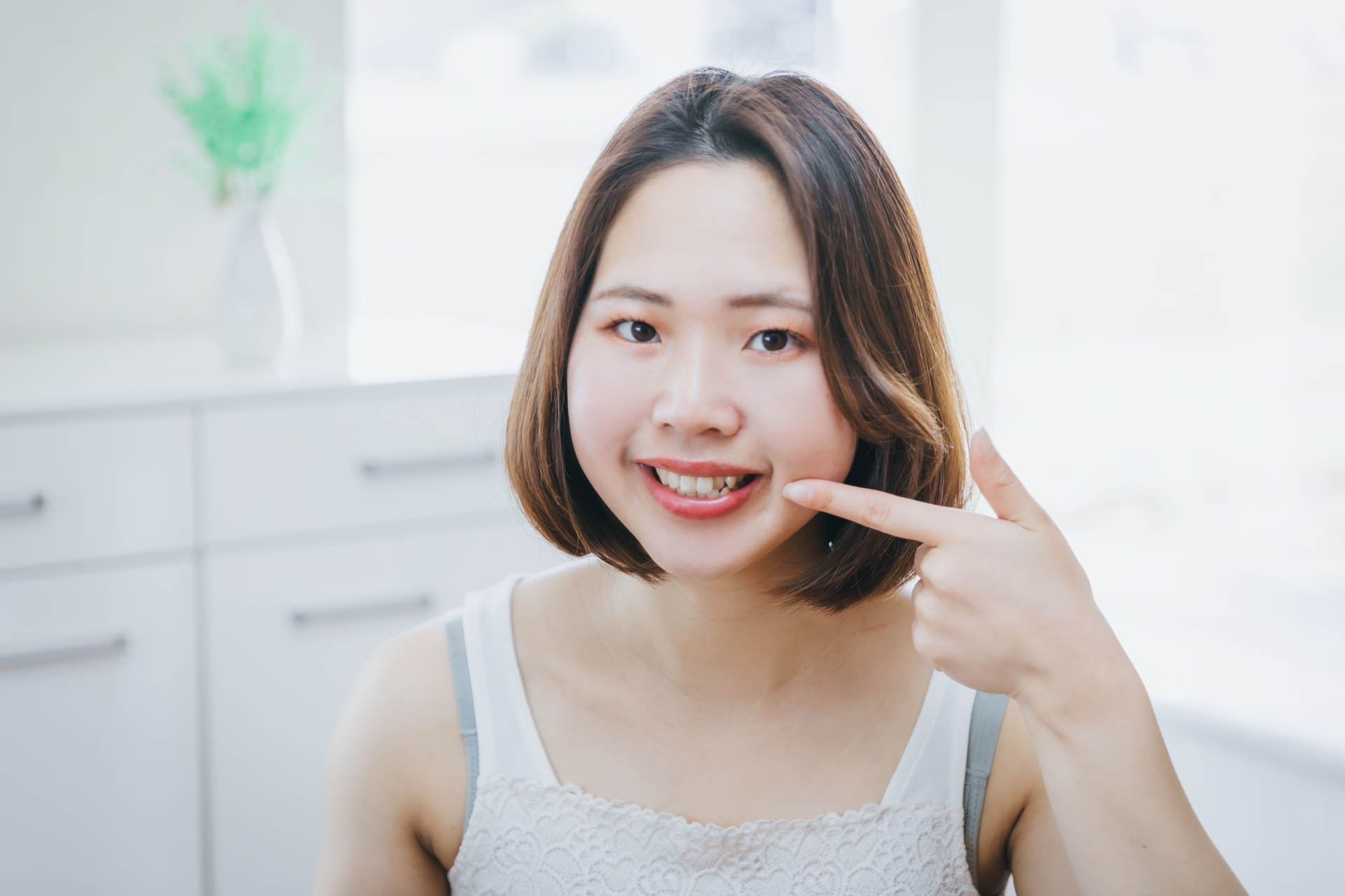 歯を指さす女性